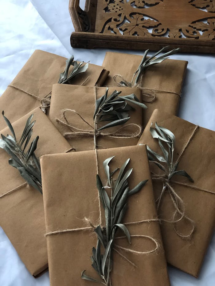 Rustic Christmas gifts wrapped in brown paper with twine and leaves.